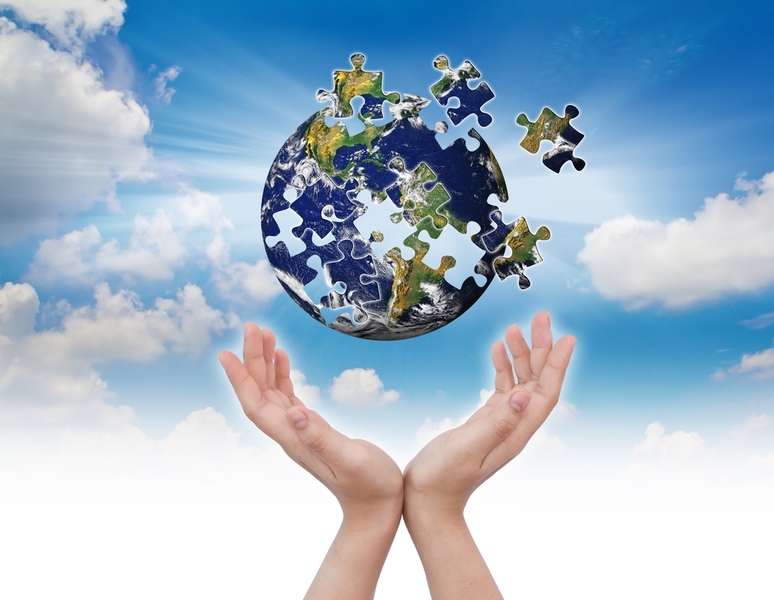Earth as a puzzle with pieces flying into the sky, while a pair of human hands are underneath