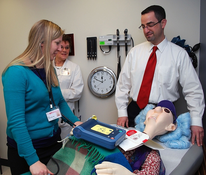 During an emergency drill at MIT Medical, Nurse Amy Chilton, left, and Internist Brian Ash attempt to “resuscitate” a life-size dummy that, in this mock scenario, has suffered cardiac arrest in Ash’s examination room. Triage Nurse Lynn Forgues, rear, acts as “recorder,” taking notes of times and activities, such as drugs administered and changes in heart rhythm.