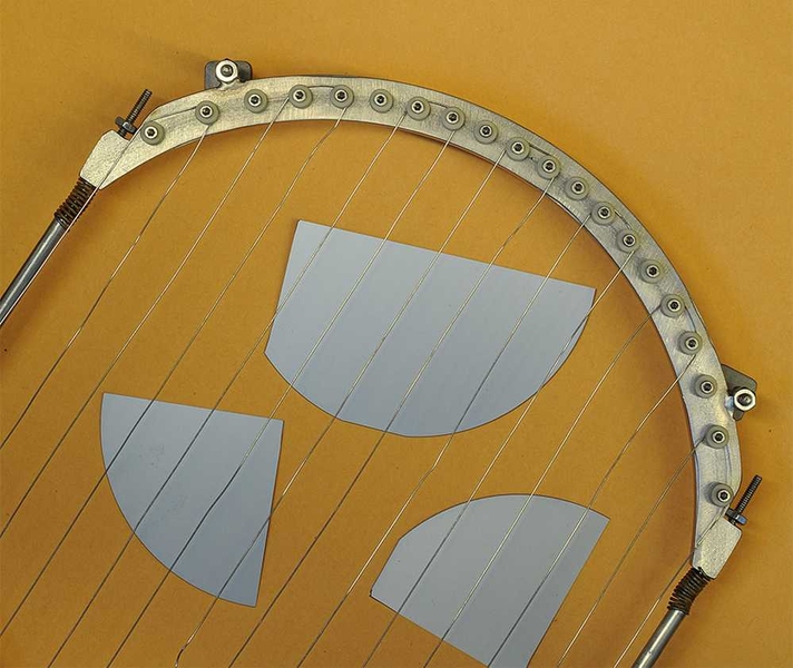 Pieces of a silicon wafer (in gray), used for solar cells or computer chips, can be coated or "passivated" using a vapor deposition process, in which the wires shown here are heated to vaporize polymer materials which then are deposited to coat the surface.