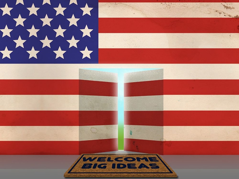 U.S. flag wall with an open door and a mat that says "Welcome big ideas"