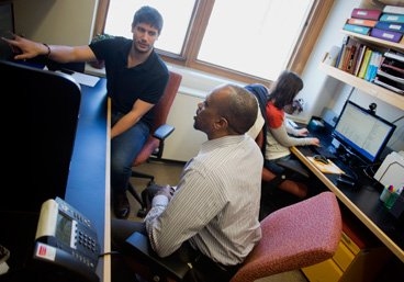 Collin Stultz, an associate professor of electrical engineering and computer science (center), with two of his graduate students: Thomas Gurry, left, and Orly Ullman, right.