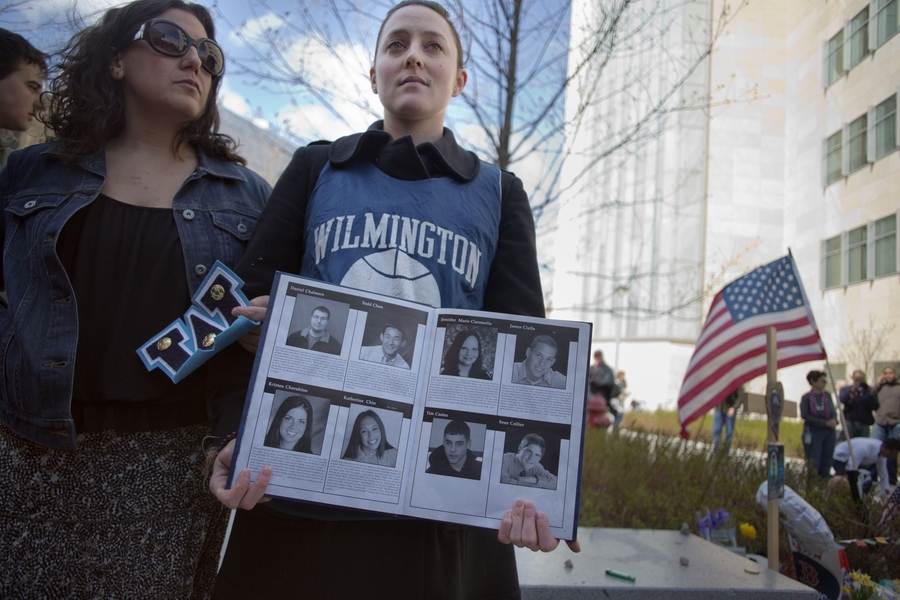 Jennifer Earls, a prehealth advisor in MIT's Global Education and Career Development Center, who went to high school with Collier, stood with their yearbook near the memorial.