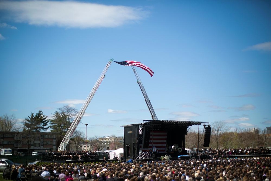 A U.S. flag flew above and behind the stage, propped by two ladder trucks from the Cambridge Fire Department.