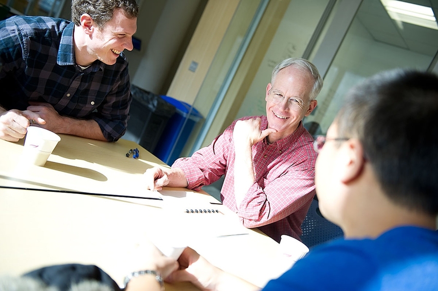 Three men in discussion at a table