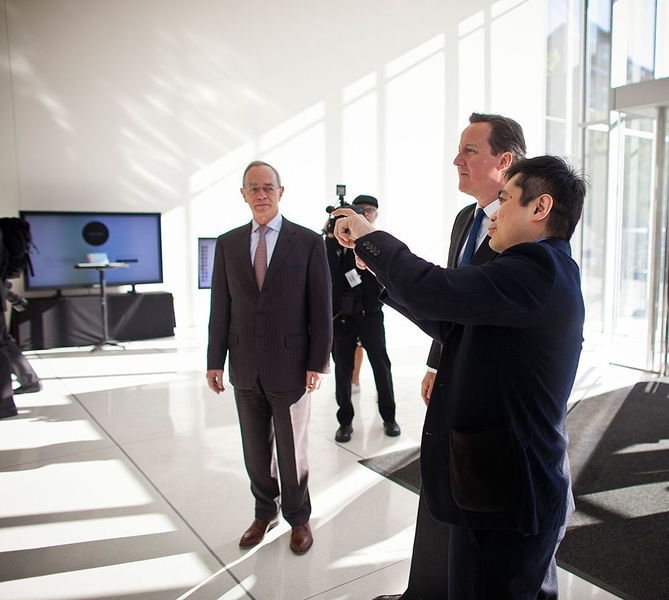 MIT Media Lab director Joichi Ito (right) shows Cameron around the lab.