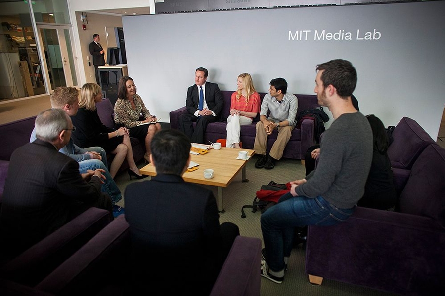 Cameron, center, hears about student entrepreneurship at MIT from a group of students and alums, as MIT Sloan professor Fiona Murray, to his right, introduces the group.