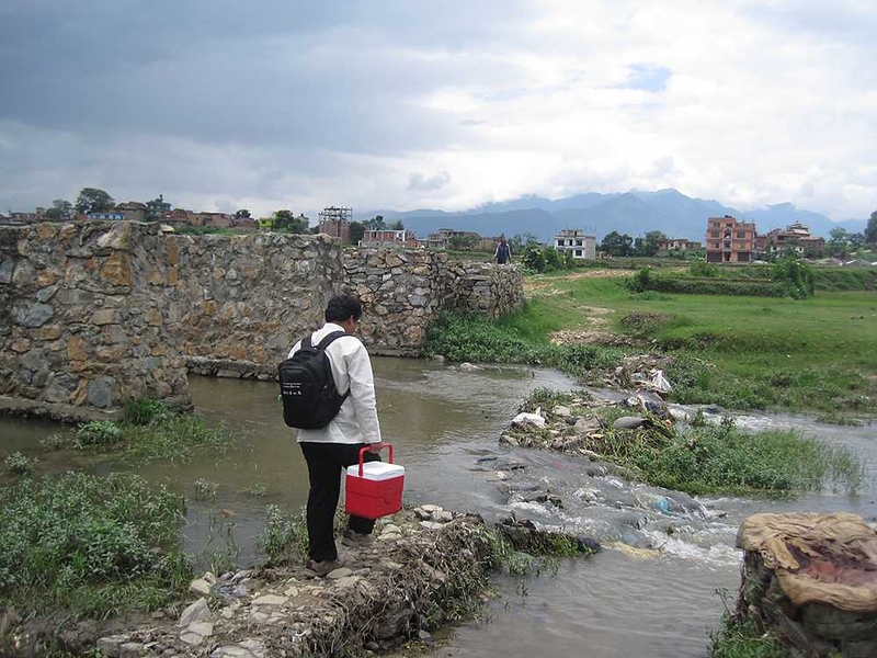 Shambhu Baral, Shawn Wen's field research partner, carries a PortaTherm prototype while walking to one of 19 peri-urban and rural health posts where they conducted product demos and interviews with health workers last summer.