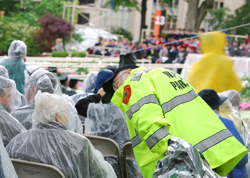 MIT EMS Clinical Director Mark Forgues, checks in with an elderly Commencement guest while distributing space blankets at MIT’s 2013 Commencement.