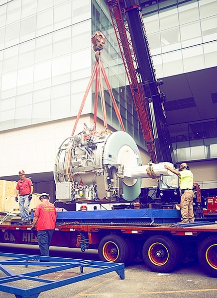 A crane hoists a 13-ton MRI scanner outside of the McGovern Institute for Brain Research at MIT.