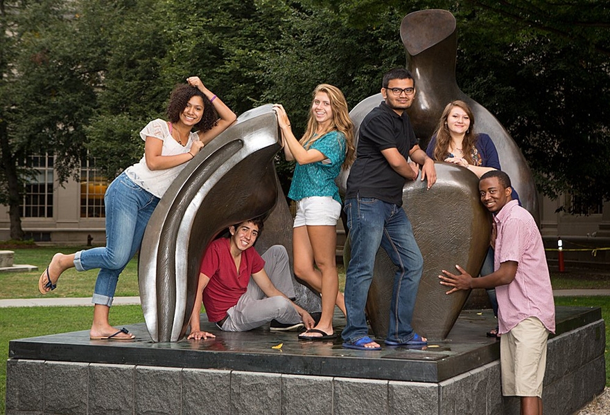 six students pose on large sculpture