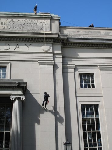 Nate Ball and Bryan Schmid scale a building on the MIT campus.