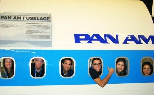 MIT LGO students playfully gaze from the windows of a airplane fuselage at Boeing.