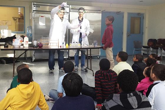 Suan Tuang explains an experiment in front of crowd of elementary school students