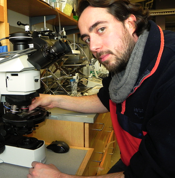 MIT postdoc associate Davide Ciceri with microscope that can analyze thin-sections of samples of processed feldspar using both reflected and transmitted light. 