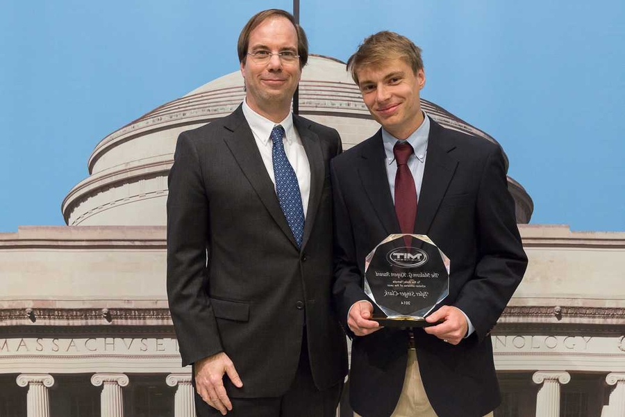 Steven Hall, chairman of the faculty (left), presents senior Tyler Singer-Clark with the Malcolm G. Kispert Award.