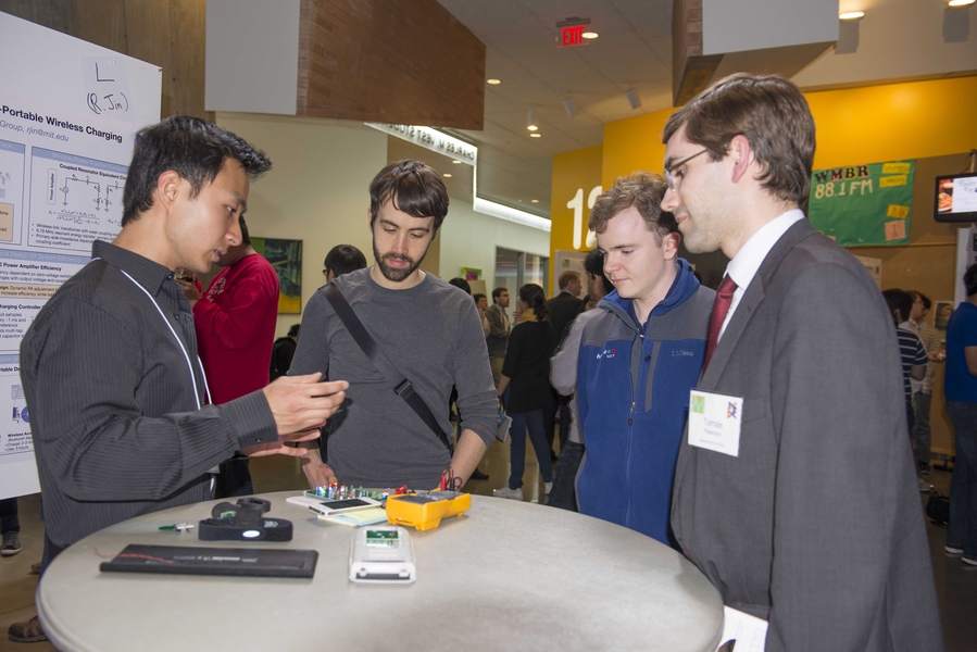 Rui Jin explains his wireless charging system to several students and to EECS professor Tomas Palacios, right.