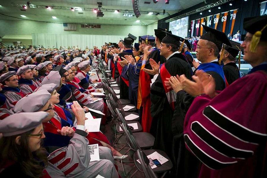 Members of the MIT faculty (right) rose to salute the Institute's newest recipients of advanced academic degrees.