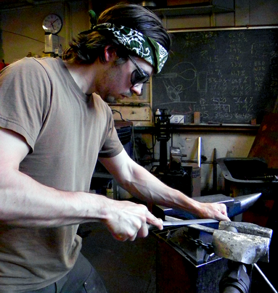 Fifth-year graduate student James Hunter files a metal blade for a wood splitting tool, known as a froe, in the MIT Glass Lab and Forge. Hunter, who has been blacksmithing and metalworking since age 13, helps supervise a class in the Forge.