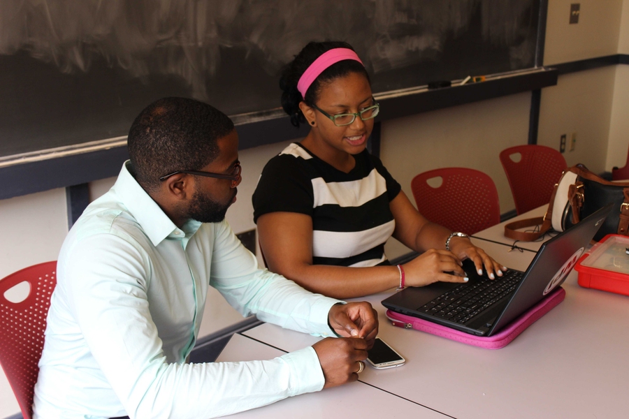 STEM Program instructor Liliana Almonte (right) discusses her proposed biology curriculum with advisor Cyrus Washington. Instructors met with experienced teachers and subject matter experts to fine-tune their curricula. Washington is pursuing a graduate degree in immunology at Harvard Medical School.