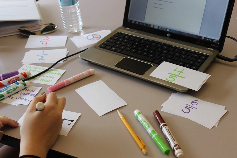 Algebra instructors Stephanie Kilponen and Lois Moon create fraction flashcards for their level one students. STEM Program students were divided into four levels based on the grades they will enter in the fall, and each level is further divided into two courses. Level-one students, who are rising sixth graders, studied biology and algebra.