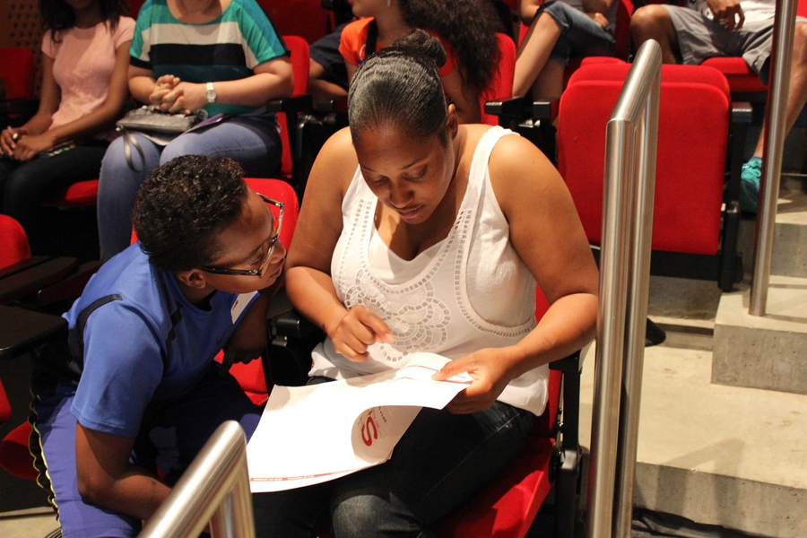 Clyde Jefferson and his mother flip through the family handbook during orientation on Wednesday, July 2 in the Ray and Maria Stata Center at MIT. During the orientation, families prepared for the program and met the instructors and staff.