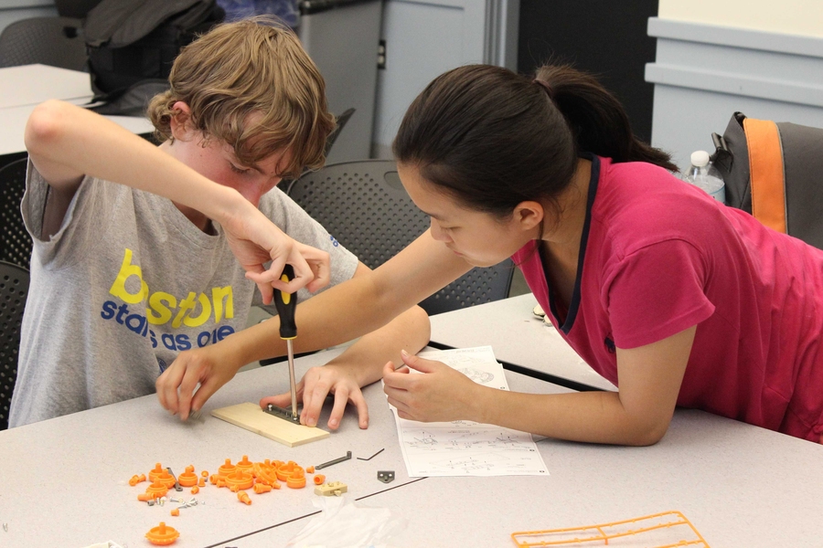 Level-three engineering design students William Harney and Lucia Pan work together to build an electronic car.