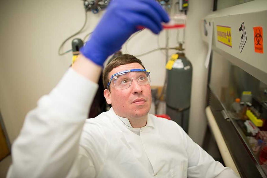 Jeffrey Wagner looks at test tube in lab