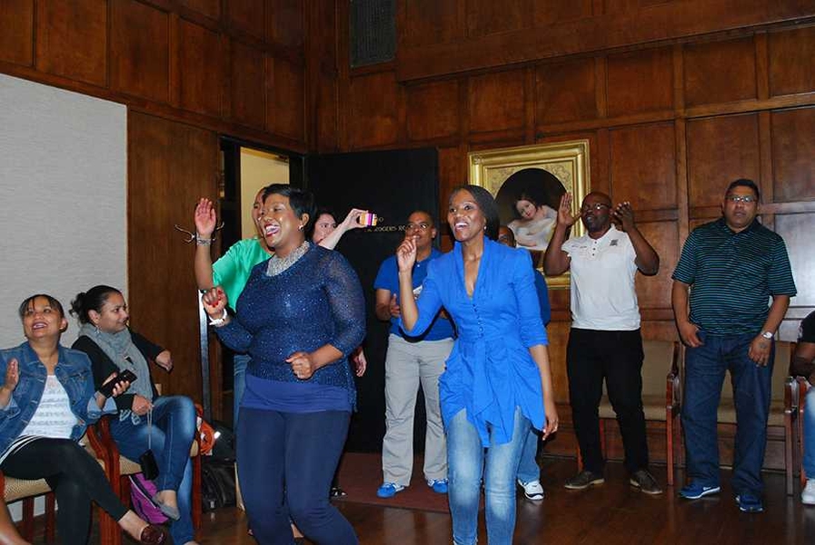 Participants singing and performing a “thank you” dance at the program's farewell reception.