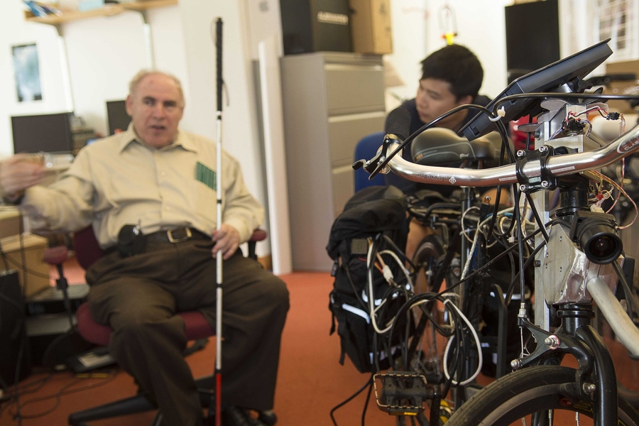 William Li, right, graduate student and lead co-instructor for 6.811 (Principles and Practices in Assistive Technologies) met last month with client Jeffrey Drucker, left, who shared his experience as a person who is visually impaired. In the foreground is the blicycle, a bicycle for people who are visually impaired and one of many assistive technologies under development in the CSAIL laboratory o...