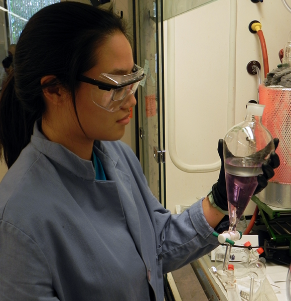 Julia Zhao holds a separation funnel, which is used to separate aqueous and organic phases of a solution. Stain was added to enhance the image. Zhao worked on a project to control the number of defects known as primary loops in most gels or elastomers and improve their mechanical properties.