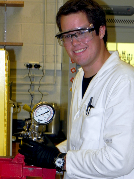 Kevin Romero holds a reactor for a water-based catalytic solution to produce a specific molecule that is an intermediate in production of certain pharmaceuticals and herbicides. Romero looked at different amounts of water, with the different catalysts, to try to make the most efficient synthesis possible.