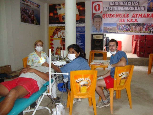 Lalani assists a local dentist with a tooth extraction in Lima.