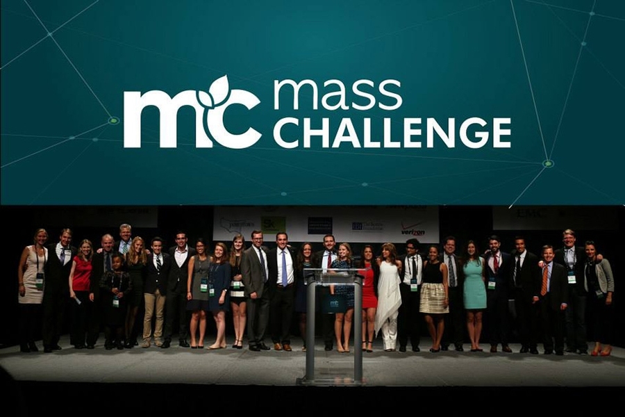 People standing side by side on stage, banner overhead says "Mass Challenge"