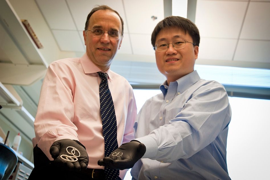Professor Michael Cima (left) and alumnus Heejin Lee display early prototypes of the LiRIS devices. The pretzel-shaped silicone tubes can be inserted into the bladder, slowly releasing lidocaine over two weeks to treat interstitial cystitis.