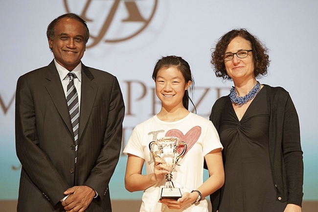 Celine Liang, first-prize winner, accepts her prize from Math Prize for Girls co-creator Arun Alagappan and MIT mathematics professor Gigliola Staffilani.