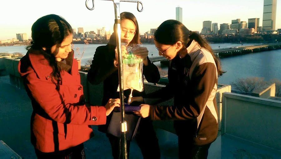 Gururaj and teammates test a device to warm IV fluid on the balcony of the McCormick Hall penthouse to see how the device performs in colder environments.