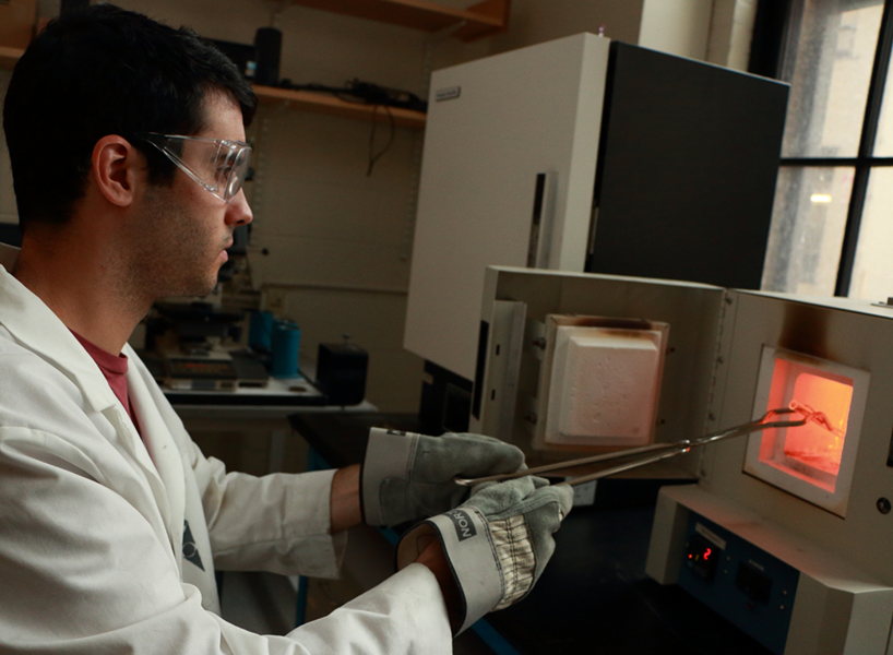 MIT graduate student Zack Cordero removes a vacuum-sealed glass ampoule from a box furnace operating at 1,100 degrees Celsius that is used to anneal metal powders.