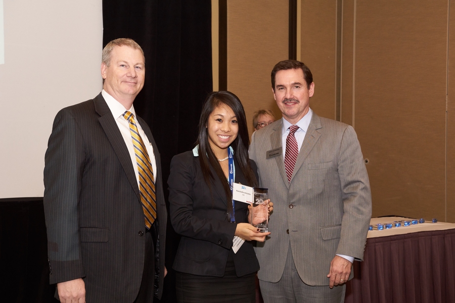 Raichelle Aniceto (center) accepted a trophy recognizing her selection as one of <i>Aviation Week's</i> "Tomorrow’s Engineering Leaders." Presenting the award at the Aerospace and Defense Programs Conference in November are Wes Kremer (left), vice president for air and missile defense systems at Raytheon Missile Systems, and Greg Hamilton, president of <i>Aviation Week,</i> right.