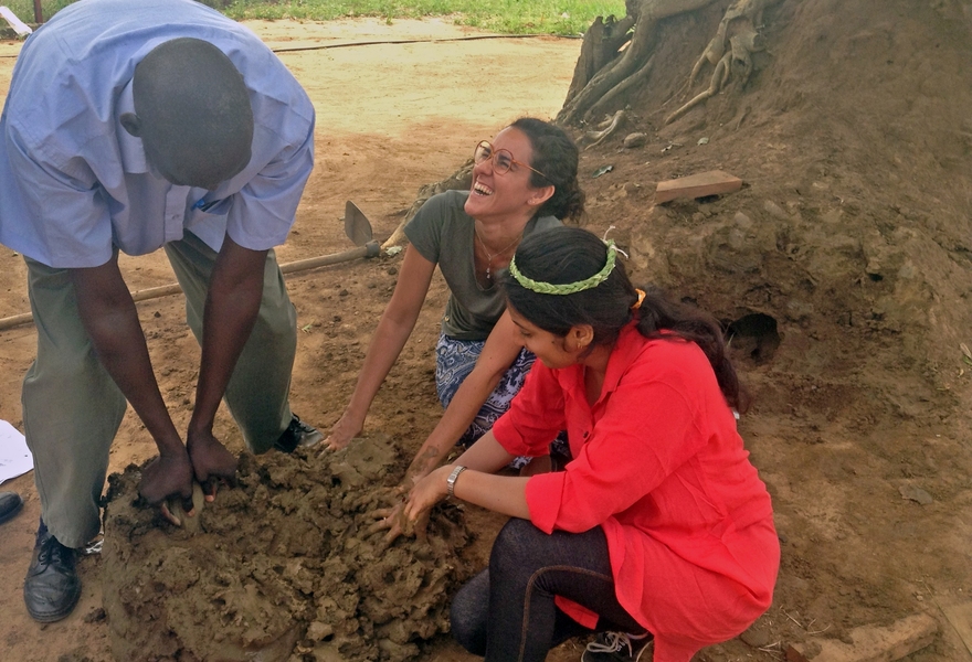 Members of the cooking team have fun getting their hands dirty while building a new kind of culturally-acceptable and user-accessible cookstove at the Rethink Relief design summit in Pader, Uganda.