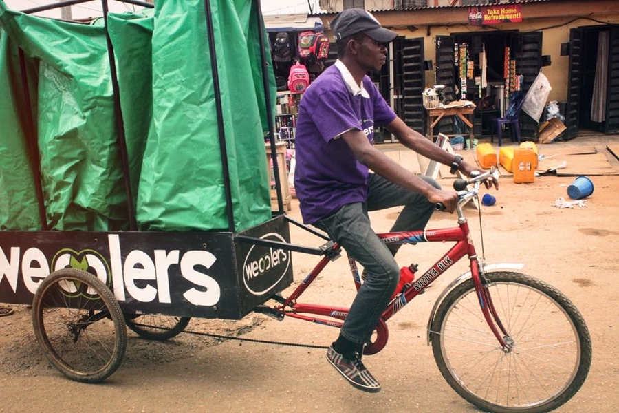 An employee rides one of the Wecyclers' cargo bikes. The startup employs locals to ride door-to-door across the slums of Lagos, Nigeria, to collect recyclables.