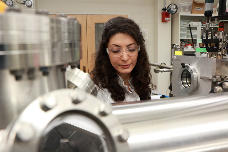 Farnaz Niroui works at a thermal evaporator, which she uses to deposit a gold coating on squeezable switches, or “squitches,” which she designed, fabricated and tested. It is part of a vacuum-sealed transfer line for making nanoscale electronic devices.