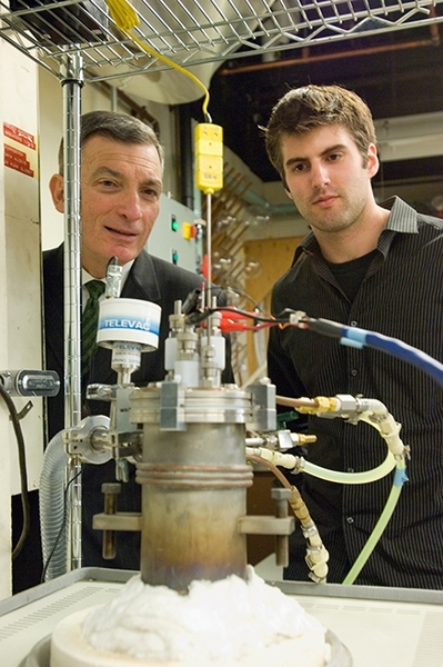 A past MITEI Seed Fund grant helped fund MIT Professor Donald Sadoway’s work, which led to the creation of Ambri, a company developing utility-scale energy storage for renewable energy. Here, Sadoway and a research affiliate observe a small test battery in the lab.