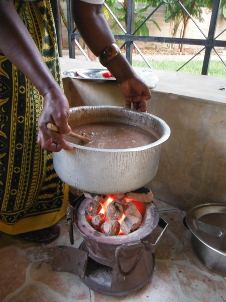 A woman cooks with agricultural-waste briquettes produced and sold by D-Lab field partner ARTI Energy in Dar es Salaam, Tanzania.