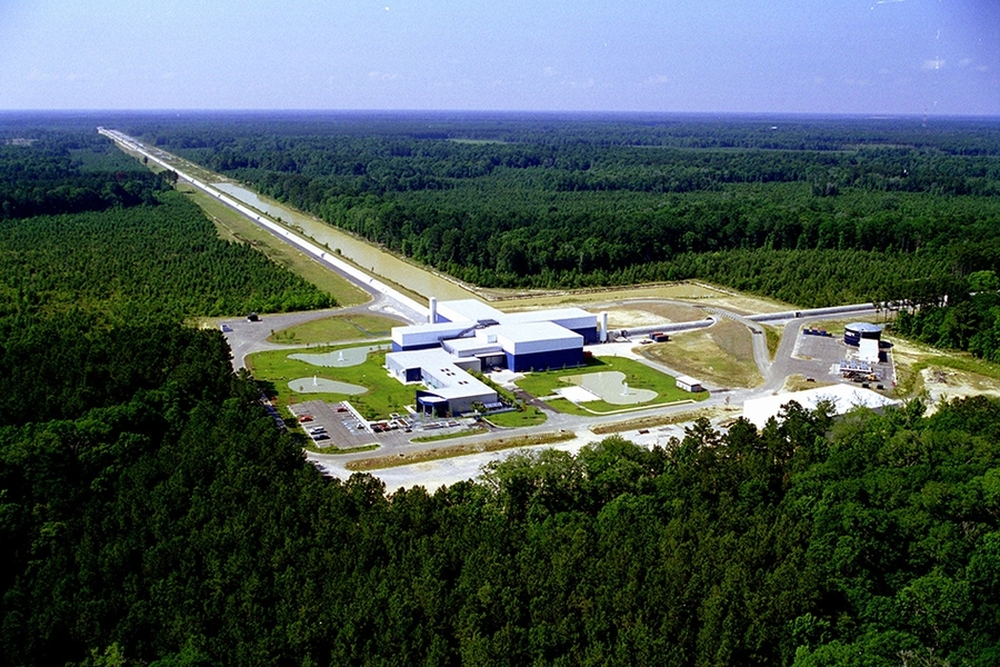 An aerial view of the LIGO Livingston Observatory shows two 4-km-long arms reaching away from the corner vertex building. 