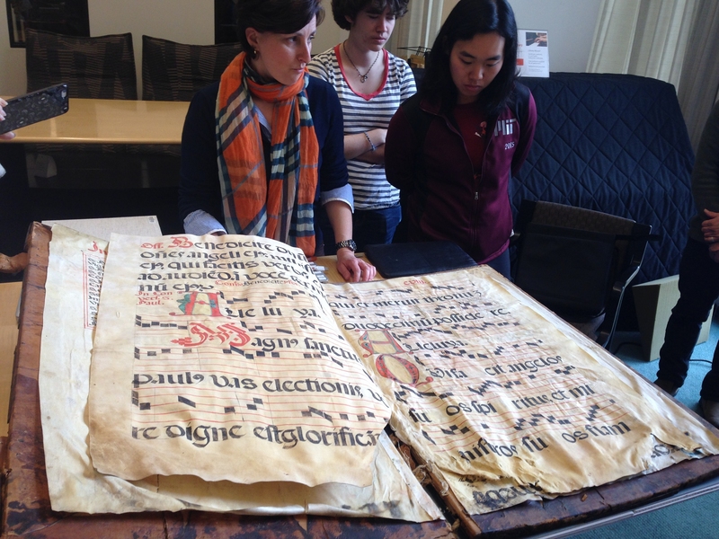 Theresa Zammit Lupi (left) with students and the Glaser Codex in the Lewis Music Library.