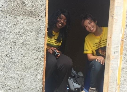 Elaine Kung '15 (right) and an MIT D-Lab teammate peer out of a their newly constructed compost toilet in Santa Ana, El Salvador.
