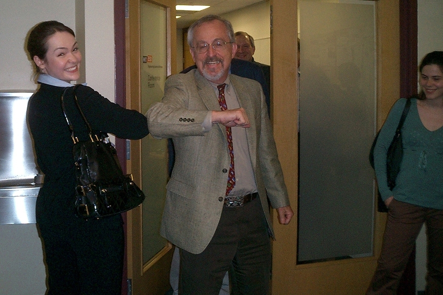 Research co-author Karima Nigmatulina bumps congratulatory elbows with advisor Richard Larson as co-authors Anna Teytelman and Stan Finkelstein look on.