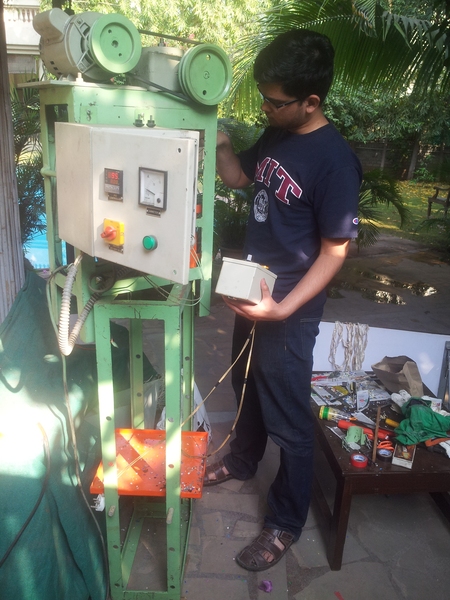 Sidhanth Pai '14 works on ReFilBot, a machine used for transforming recycled plastic flakes into 3-mm 3-D printing filament.