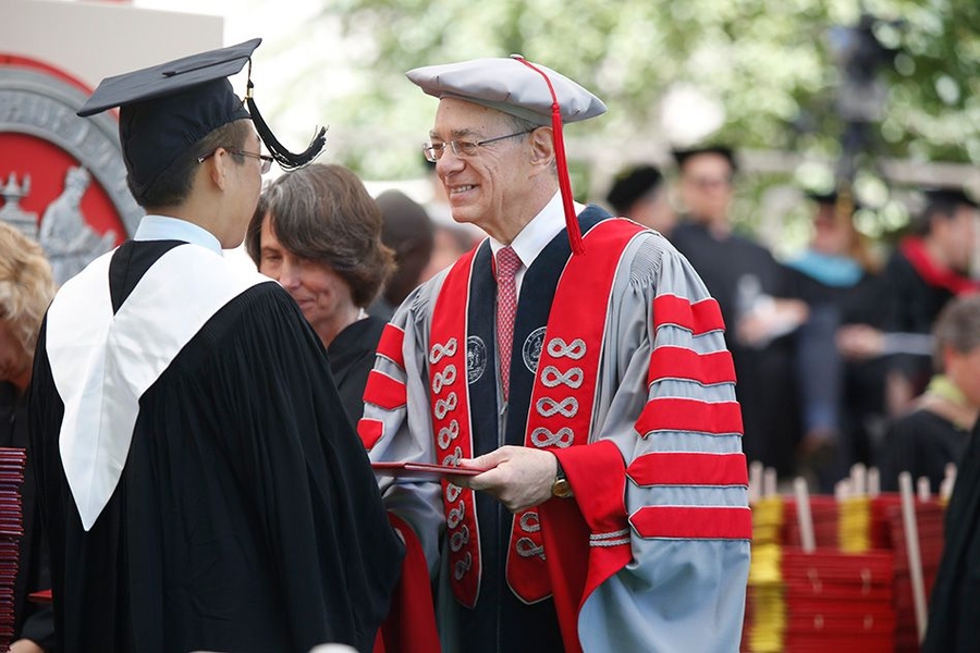 President L. Rafael Reif hands a diploma to a new graduate.