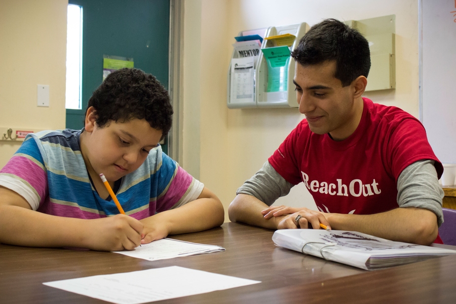 Jeffery Flores, a student in the after-school program at East End House, is doing his homework with help from MIT senior Dario Garcia-Dominguez.